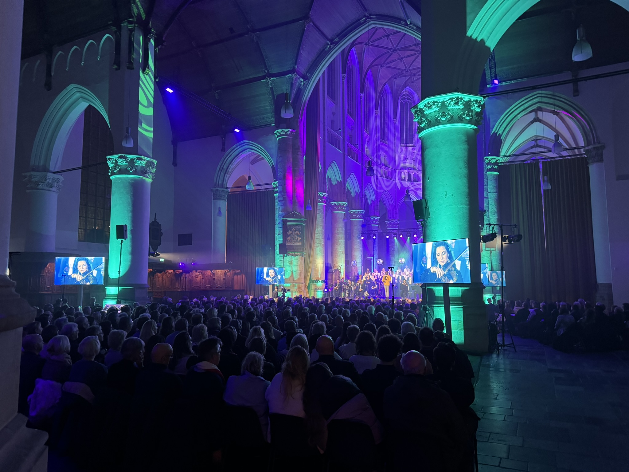 Kerk in blauw en groen licht tijdens een avondvullend evenement